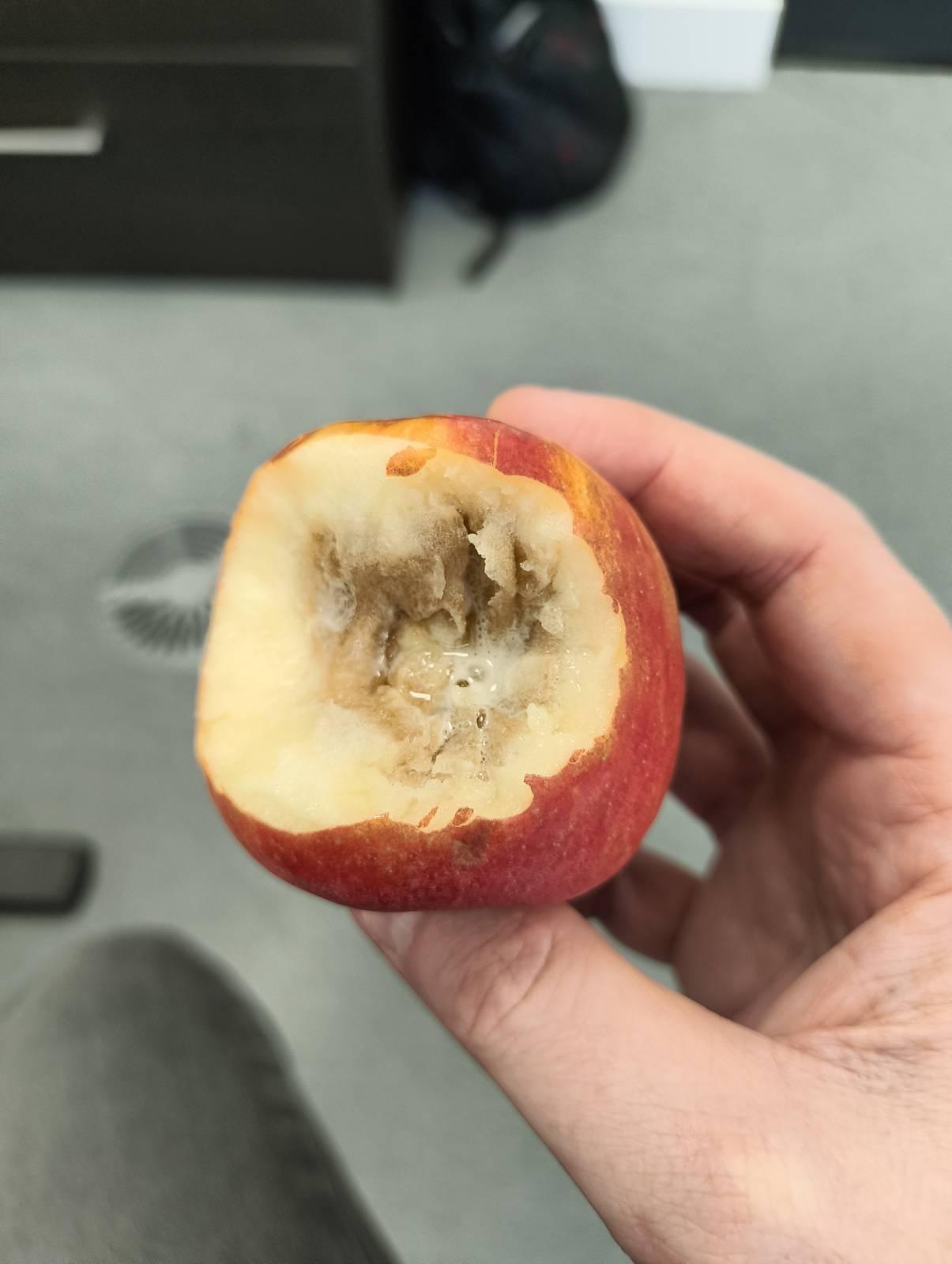Partially rotten apple that's been bitten in to.